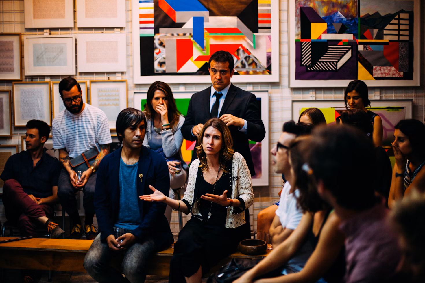 A person speaking to a small group near a whiteboard.