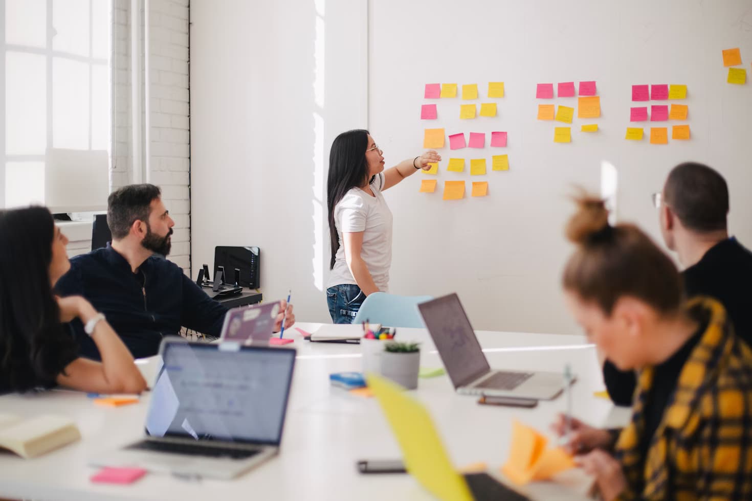 People collaborating with sticky notes in a meeting room.